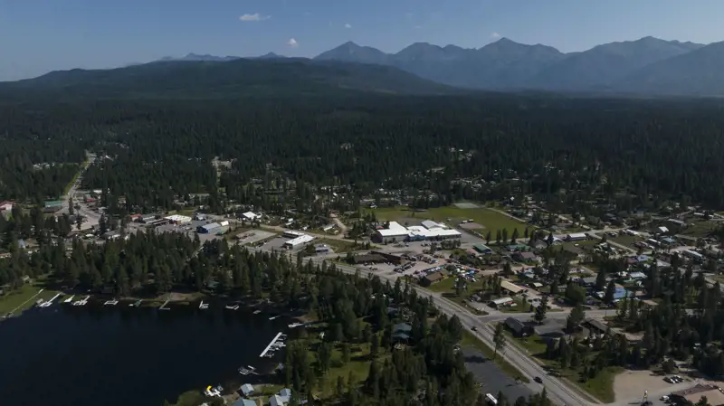 Aerial view of downtown Seeley Lake in summer with mountains in the background